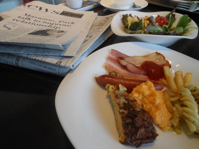 新聞を読みながら朝食