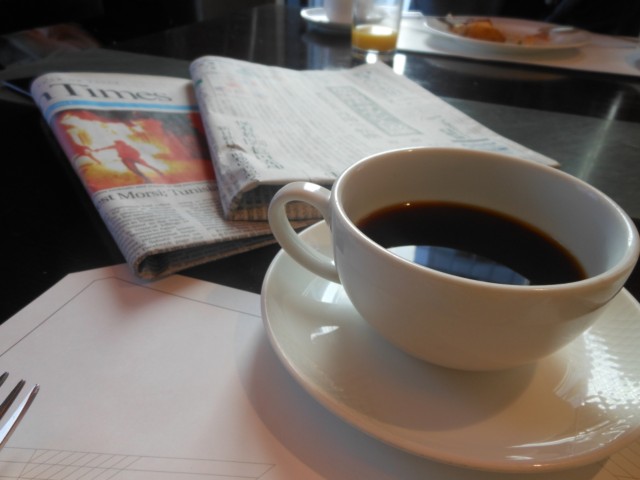 新聞を読みながらコーヒーで一休み